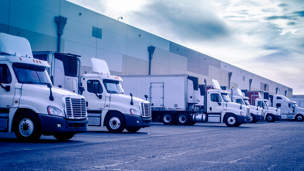 Des camions semi-remorques chargés et déchargés dans un entrepôt.